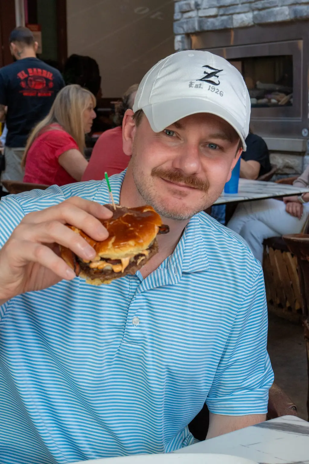 A guest grinning with his burger