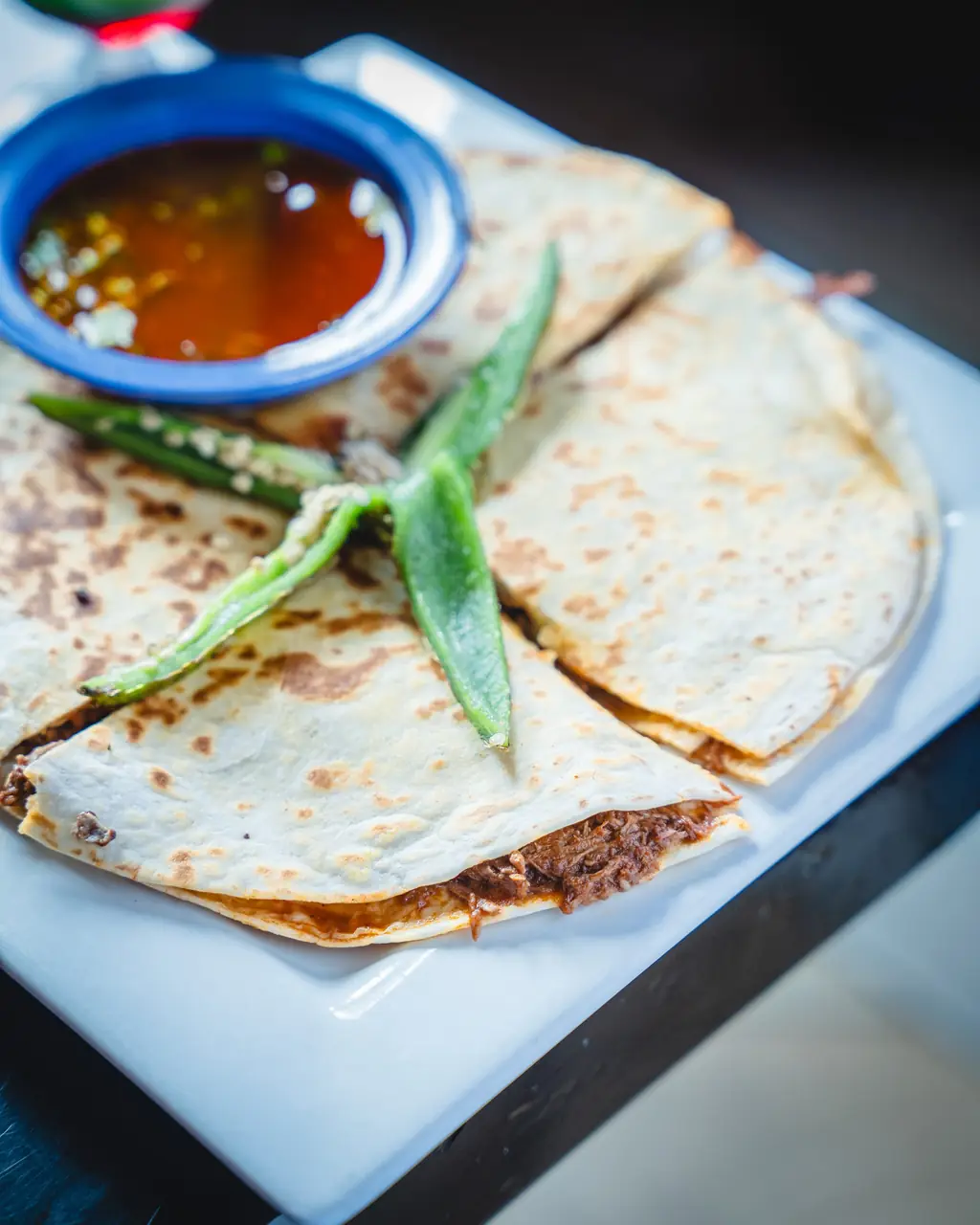 Quesabirria wedges with consome and grilled chiles
